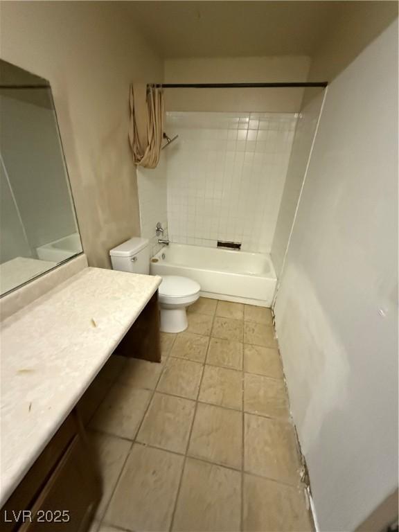 full bathroom featuring vanity, tile patterned flooring, tiled shower / bath combo, and toilet