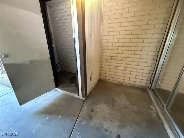 bathroom with concrete floors and brick wall