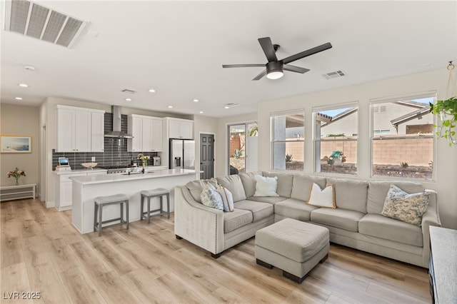 living room with light wood-type flooring and ceiling fan