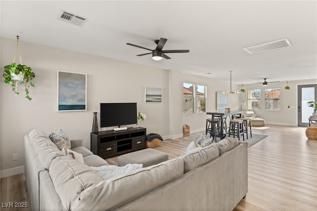 living room with ceiling fan and light wood-type flooring