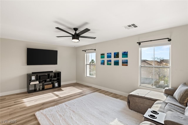 living room with ceiling fan, light hardwood / wood-style floors, and plenty of natural light