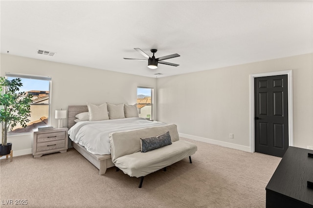 bedroom with ceiling fan, light carpet, and multiple windows