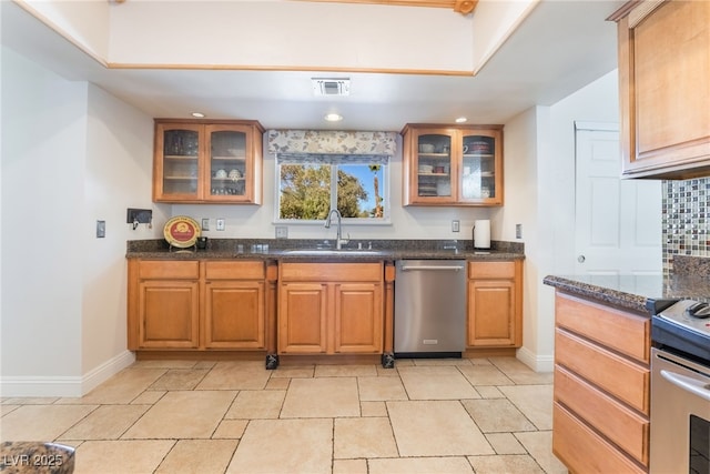 kitchen with sink, stainless steel appliances, and dark stone countertops