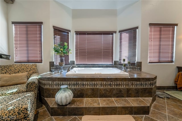 bathroom with tile patterned flooring and tiled bath