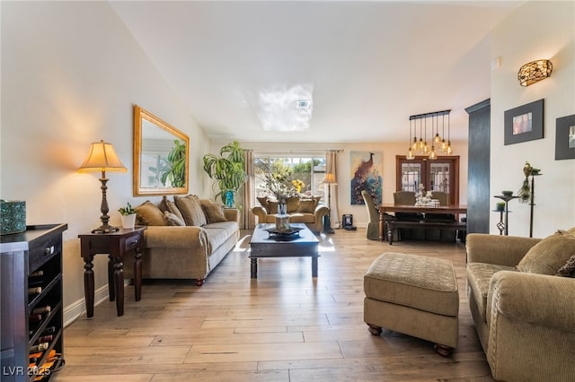 living room with vaulted ceiling and light hardwood / wood-style flooring