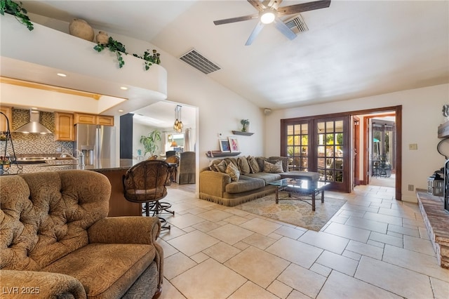 living room featuring ceiling fan, vaulted ceiling, and light tile patterned flooring