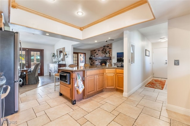 kitchen featuring stainless steel appliances, sink, french doors, ornamental molding, and a brick fireplace