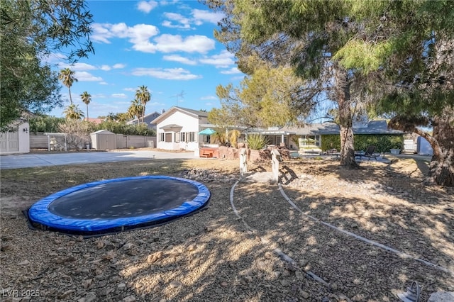 view of yard with a storage unit and a trampoline