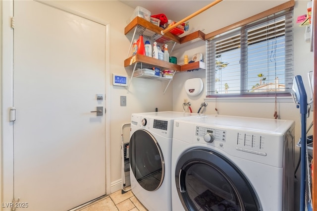 laundry area featuring washer and clothes dryer and light tile patterned floors