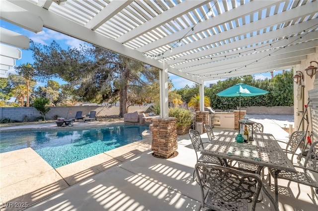 view of pool featuring exterior kitchen, a pergola, and a patio area