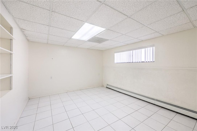 spare room with a baseboard heating unit and a drop ceiling