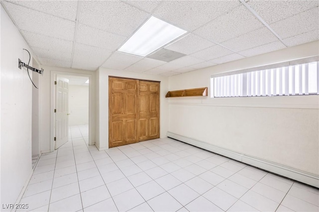 unfurnished room featuring a paneled ceiling and a baseboard radiator