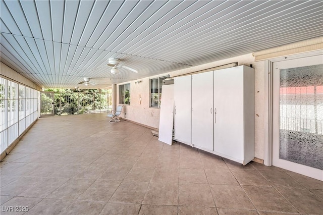 unfurnished sunroom with ceiling fan