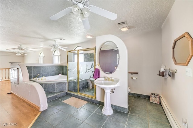 bathroom with toilet, a textured ceiling, shower with separate bathtub, baseboard heating, and tile patterned floors