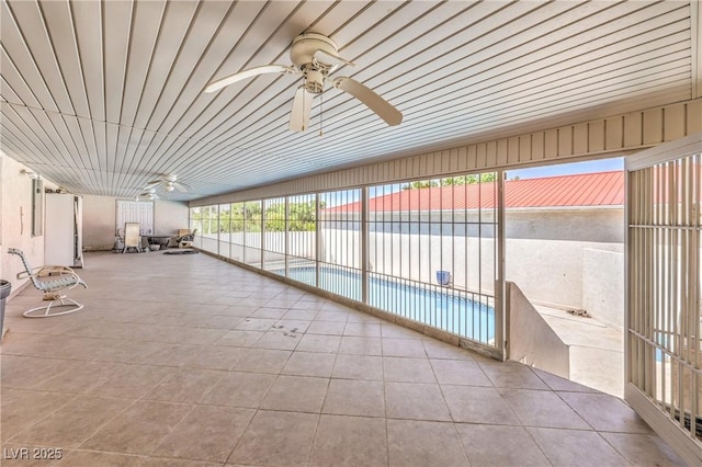 unfurnished sunroom featuring ceiling fan