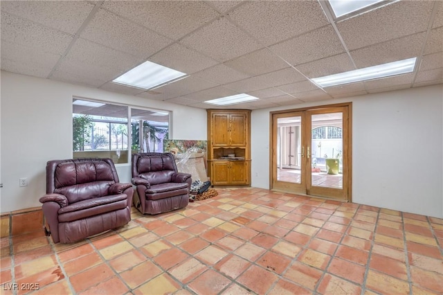 living room featuring a drop ceiling and french doors