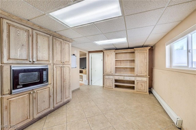 kitchen with baseboard heating, black microwave, a paneled ceiling, and light brown cabinets