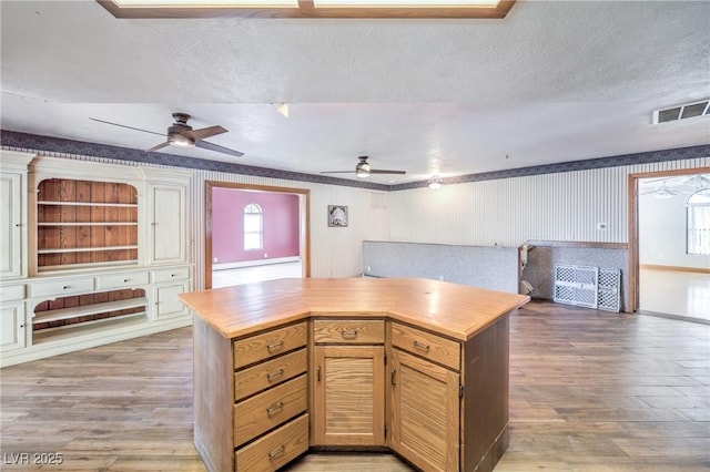 kitchen featuring a textured ceiling, a healthy amount of sunlight, and light hardwood / wood-style flooring