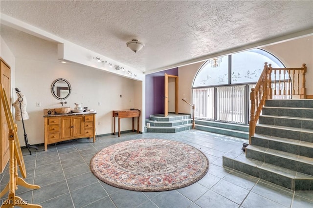 interior space featuring dark tile patterned flooring and a textured ceiling