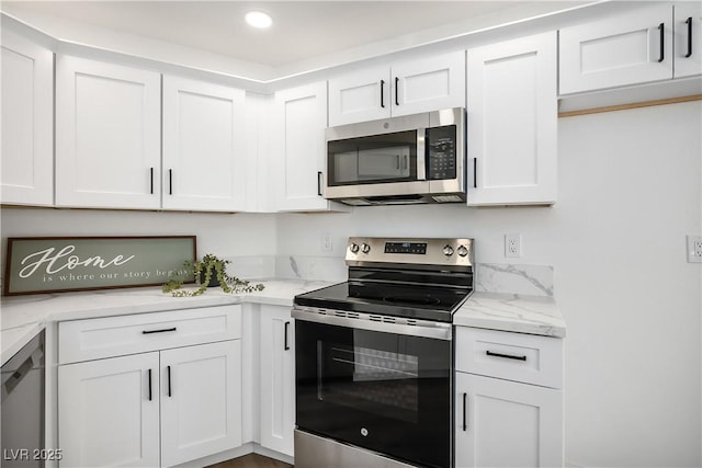 kitchen featuring light stone counters, stainless steel appliances, and white cabinets