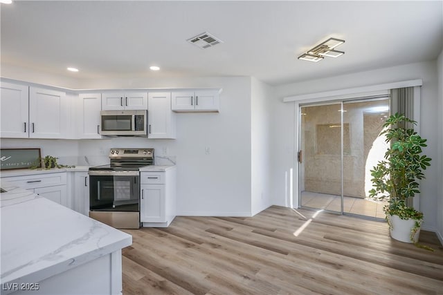 kitchen with light hardwood / wood-style flooring, stainless steel appliances, white cabinetry, and light stone countertops