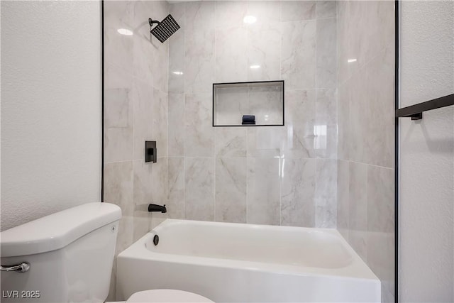 bathroom featuring toilet and tiled shower / bath