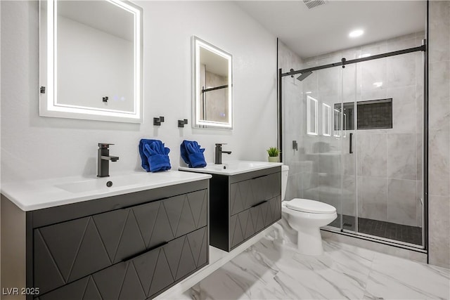 bathroom with toilet, vanity, and a shower with shower door