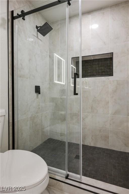 bathroom featuring toilet and an enclosed shower