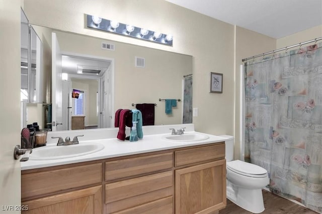 bathroom with toilet, wood-type flooring, and vanity