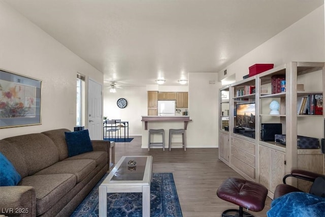 living room with ceiling fan and dark hardwood / wood-style flooring