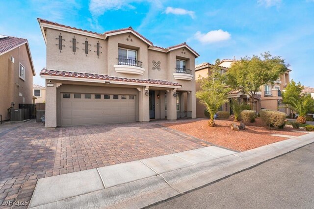 mediterranean / spanish home with a balcony, a garage, and central AC unit