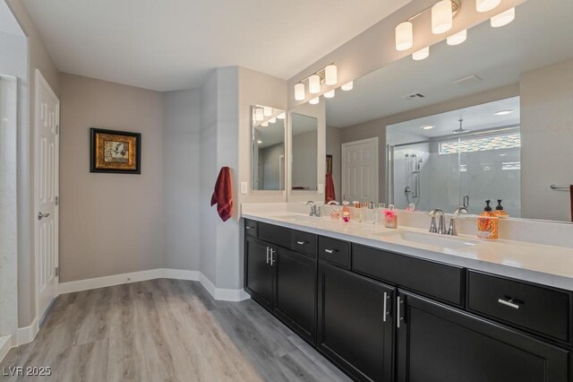 bathroom with an enclosed shower, vanity, and hardwood / wood-style floors