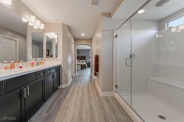 bathroom with vanity, a shower with shower door, and hardwood / wood-style flooring