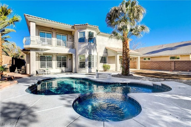 exterior space with a balcony, ceiling fan, a patio, and a swimming pool with hot tub