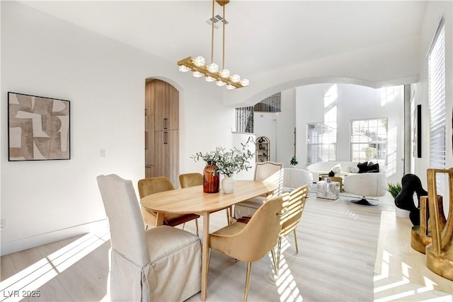 dining room featuring light wood-type flooring and an inviting chandelier