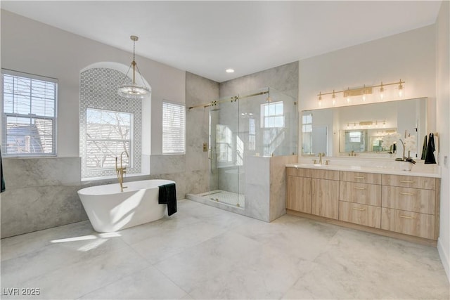 bathroom with a notable chandelier, vanity, and shower with separate bathtub