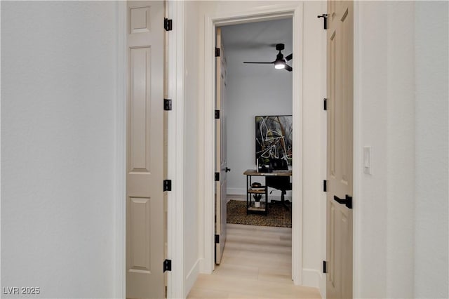 corridor with light hardwood / wood-style flooring