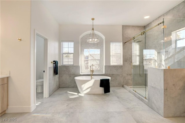 full bathroom with separate shower and tub, an inviting chandelier, vanity, and toilet