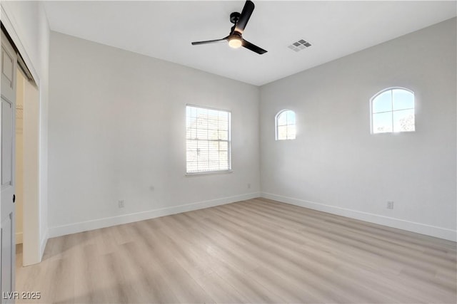 empty room with ceiling fan, light hardwood / wood-style flooring, and a healthy amount of sunlight