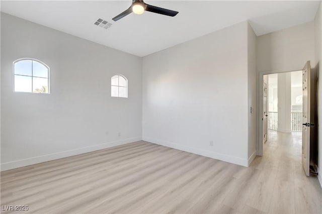 spare room featuring ceiling fan, light hardwood / wood-style floors, and a wealth of natural light