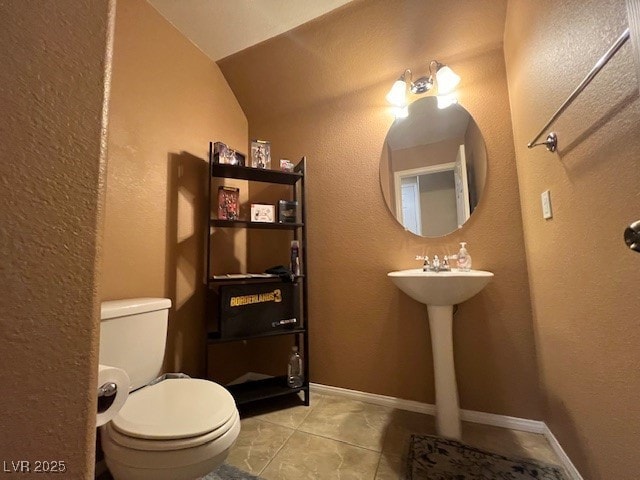 bathroom featuring toilet, tile patterned floors, and vaulted ceiling