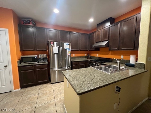 kitchen featuring appliances with stainless steel finishes, stone countertops, and dark brown cabinetry