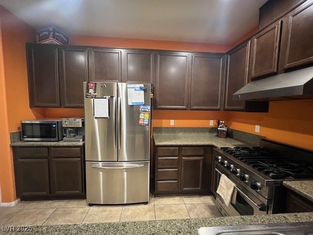 kitchen with stainless steel appliances, light tile patterned floors, and dark brown cabinetry