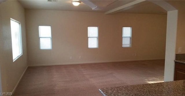 carpeted spare room with ceiling fan and beamed ceiling