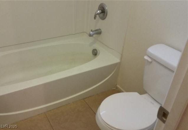 bathroom with toilet, tile patterned floors, and shower / bathtub combination