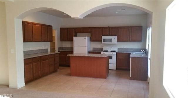 kitchen featuring a kitchen island, white appliances, and sink