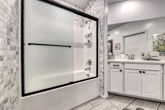 bathroom featuring shower / bath combination with glass door and vanity