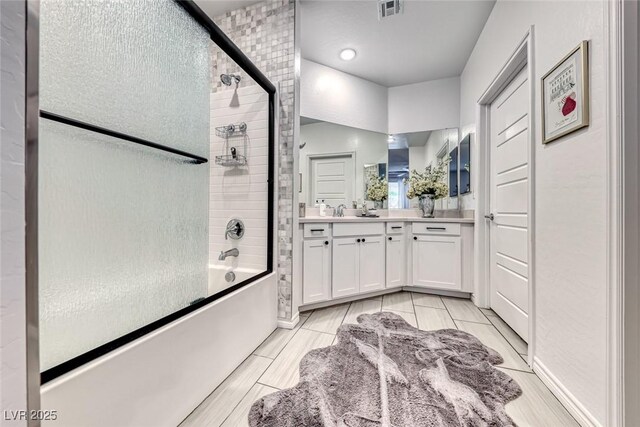 bathroom with bath / shower combo with glass door and vanity