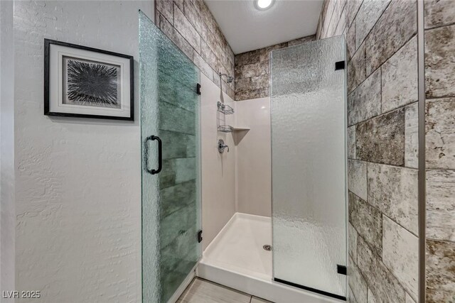 bathroom featuring tile patterned flooring and a shower with shower door