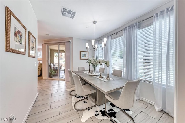 tiled dining space with a chandelier and plenty of natural light